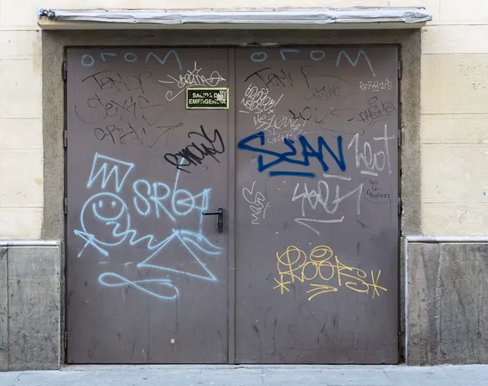 brown commercial double heavily covered in various graffiti tags and spray paint