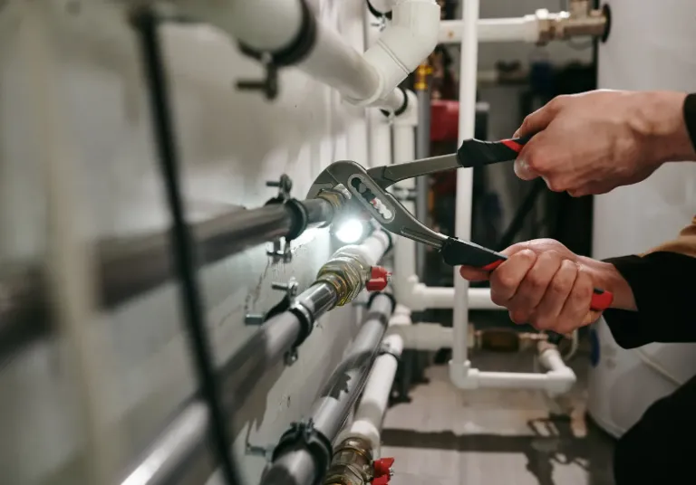 technician using wrenches to tighten pipe fittings