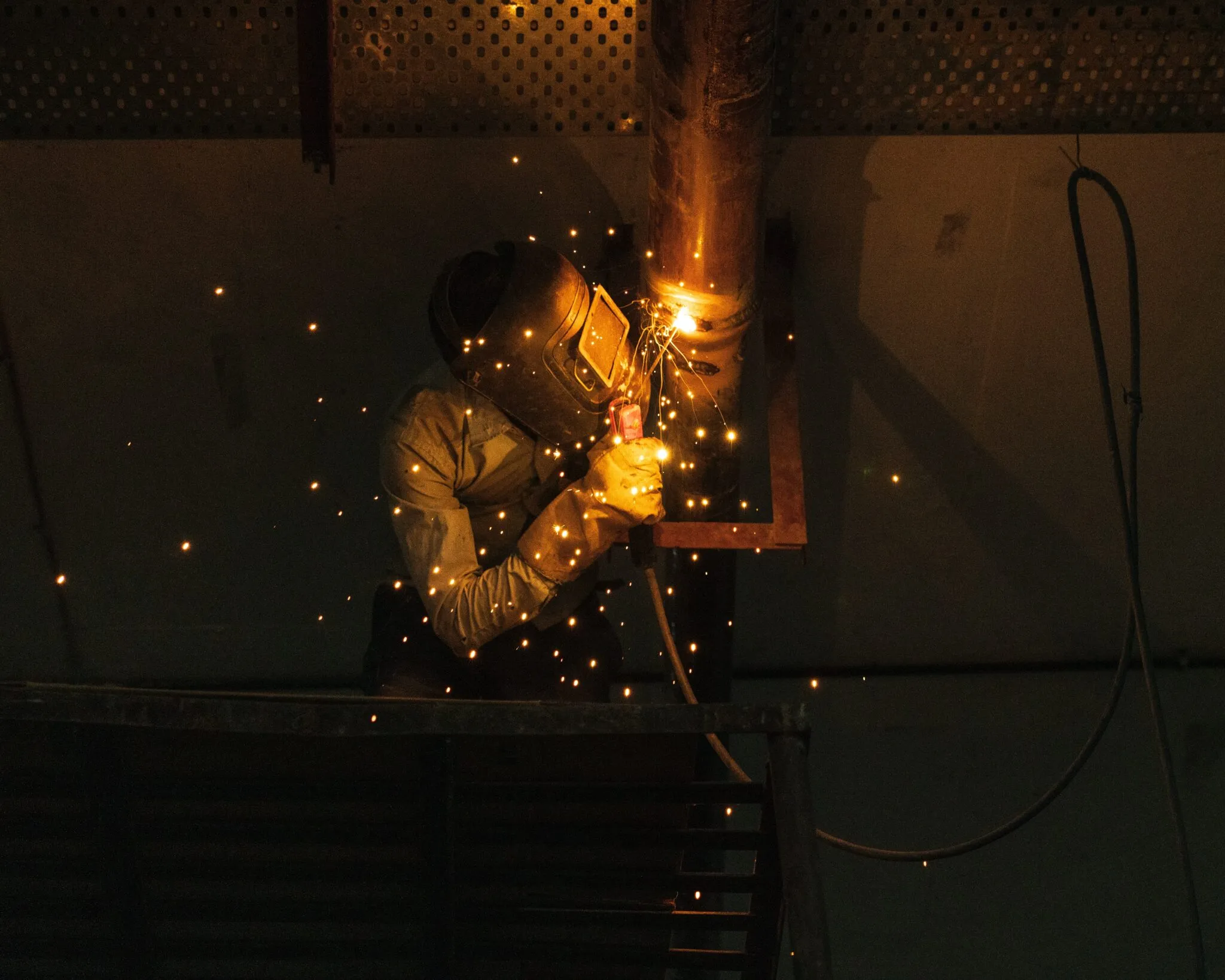 welder on a protective helmet welding metal