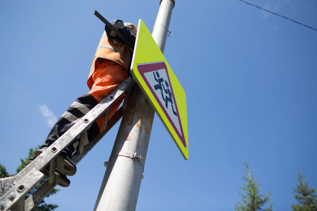 installation-road-sign-on-pole-road-worker